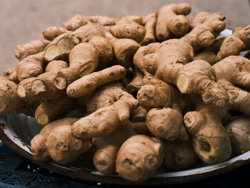 Close-up of fresh ginger roots in a bowl, highlighting its organic texture and earthy color.