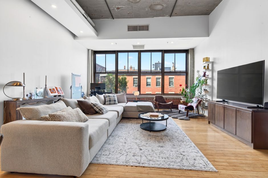 Spacious and elegant living room with modern furnishings and large windows in a Boston apartment.